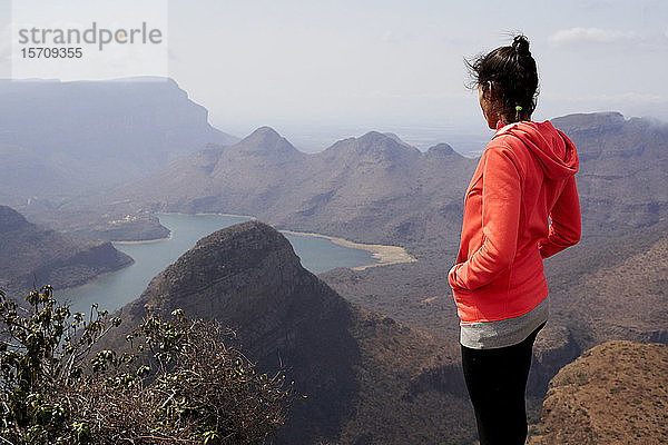 Frau  die auf einem Hügel steht und die wunderschöne Landschaft unter sich genießt  Blyde River Canyon  Südafrika.