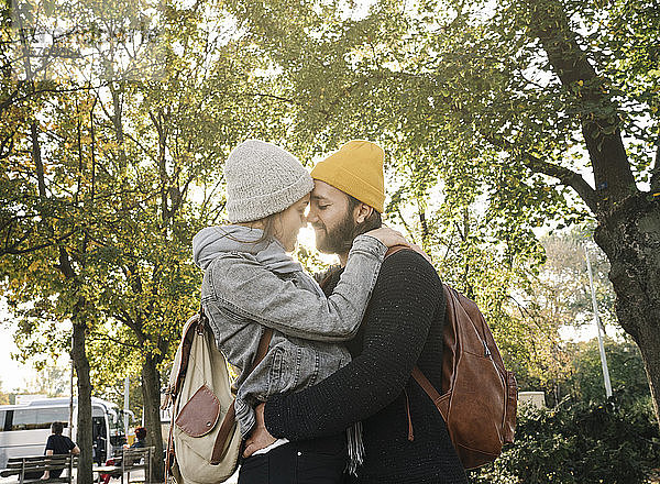 Junges Paar umarmt sich in einem Stadtpark  Berlin  Deutschland