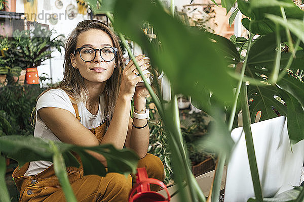 Porträt einer jungen Frau bei einer Kaffeepause in einem kleinen Gartenbaubetrieb