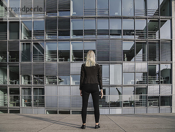Rückansicht einer Geschäftsfrau vor einem modernen Büro