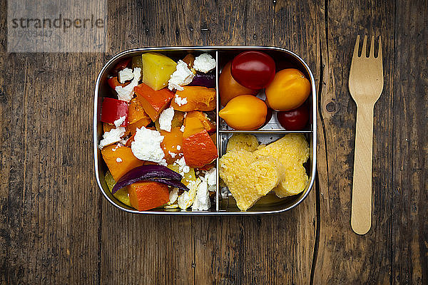 Metall-Lunchbox mit Salat aus im Ofen gebackenem Gemüse und herzförmiger Polenta