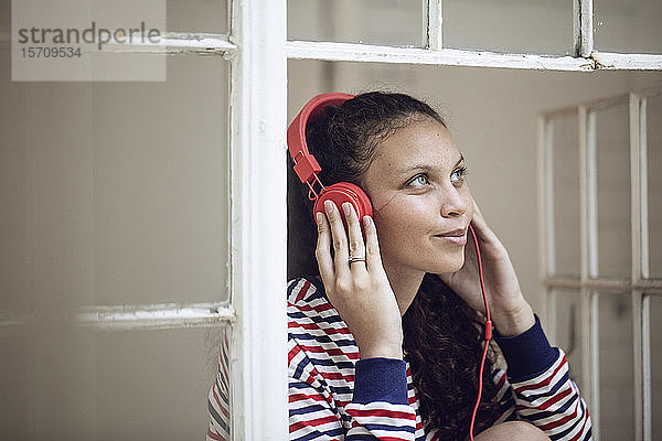 Junge Frau am Fenster  die Musik hört