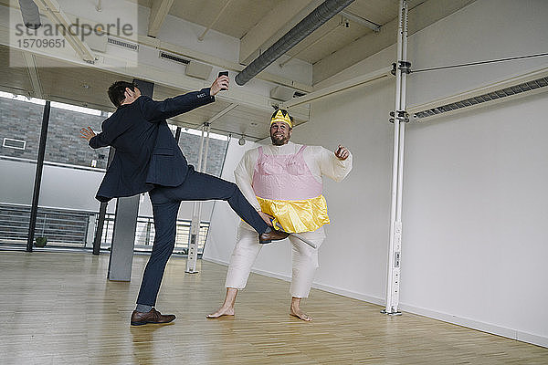 Geschäftsmann tritt als Ballerina verkleideten Mann im Amt