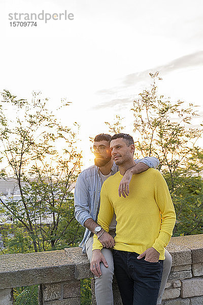Anhängliches schwules Paar bei Sonnenuntergang im Freien