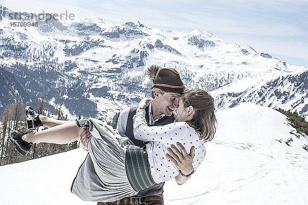Glückliches Paar küsst sich in den verschneiten Bergen  Bundesland Salzburg  Österreich