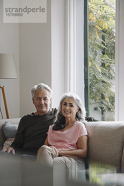 Porträt eines älteren Paares  das sich zu Hause auf der Couch entspannt