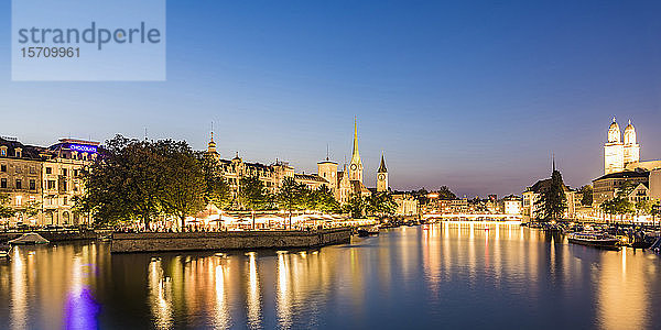 Schweiz  Kanton Zürich  Zürich  Fluss Limmat und beleuchtete Altstadtgebäude am Wasser in der Abenddämmerung