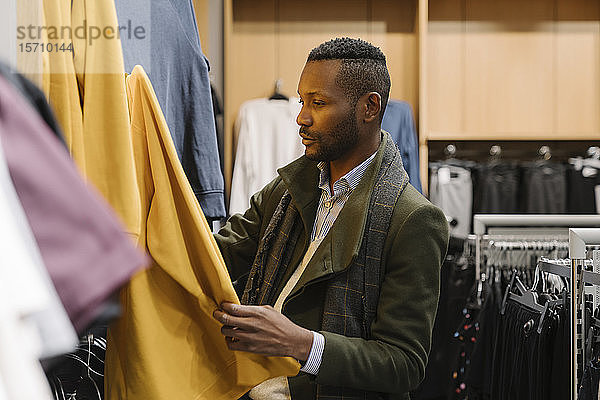 Stilvoller Mann beim Einkaufen in einem Bekleidungsgeschäft