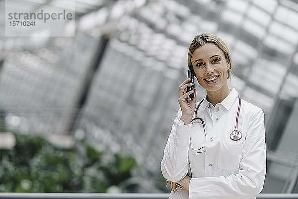 Porträt einer lächelnden Ärztin am Telefon