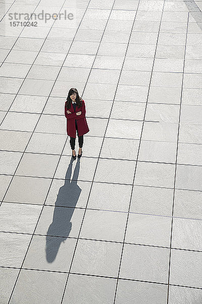 Blick von oben auf eine gehende moderne Geschäftsfrau  die auf einem Betonboden steht
