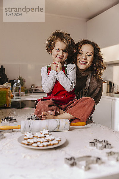 Porträt einer glücklichen Mutter und Tochter mit Weihnachtsplätzchen in der Küche