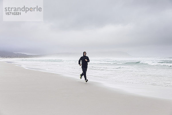 Mann joggt am Strand  Nordhoek  Westkap  Südafrika