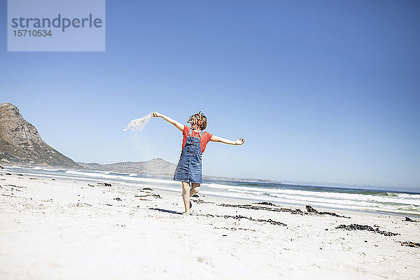 Mädchen hört Musik mit Kopfhörern  tanzt am Strand  Kapstadt  Western Cape  Südafrika