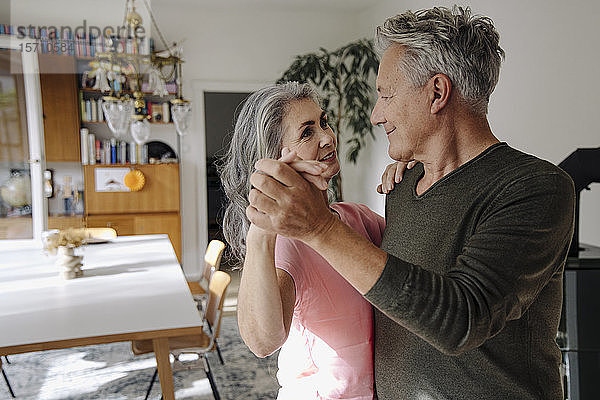 Älteres Paar tanzt zu Hause im Wohnzimmer