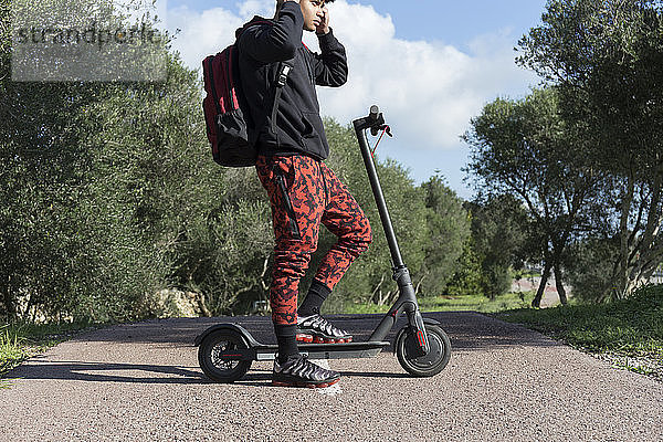 Junger Mann mit E-Scooter auf dem Fahrradweg