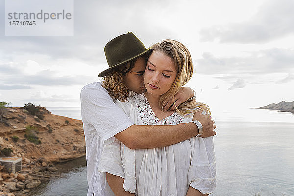 Junges verliebtes Paar steht vor dem Meer  Ibiza  Balearen  Spanien