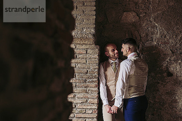 Liebenswertes elegantes schwules Paar in einem alten Gebäude