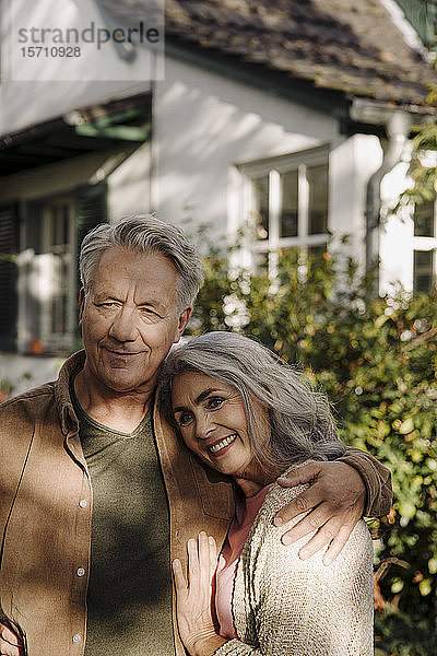 Porträt eines älteren Ehepaares im Garten ihres Hauses
