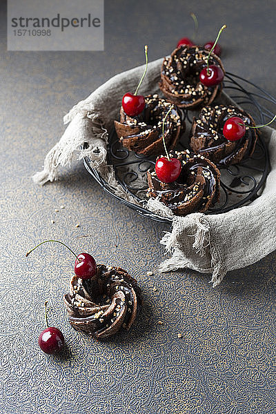 Korb mit deutschen Minigugelhupfkuchen mit Schokolade  Krokant und Kirschen