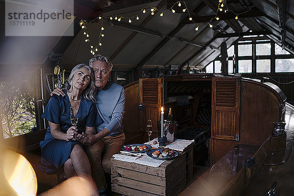 Älteres Ehepaar bei einem Candlelight-Dinner auf einem Boot im Bootshaus