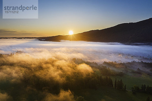 Deutschland  Oberbayern  Gaissach  Luftaufnahme des Nebels über der Landschaft bei Sonnenaufgang