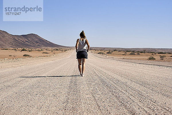 Frau  die mitten auf einem Feldweg geht  Damaraland  Namibia