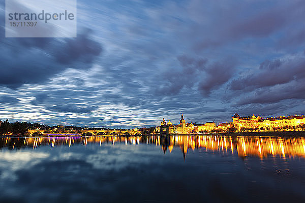 Tschechische Republik  Prag  Stadtsilhouette in der Dämmerung beleuchtet  über den Fluss gesehen