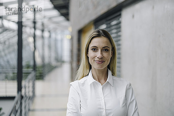 Porträt einer selbstbewussten jungen Geschäftsfrau in einem modernen Bürogebäude