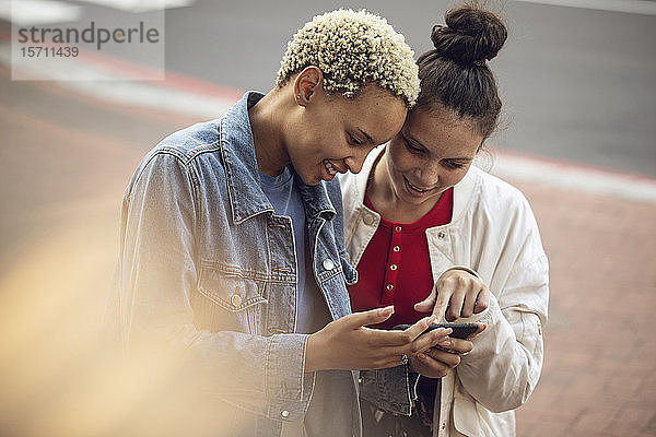 Zwei junge Frauen überprüfen Smartphone in der Stadt