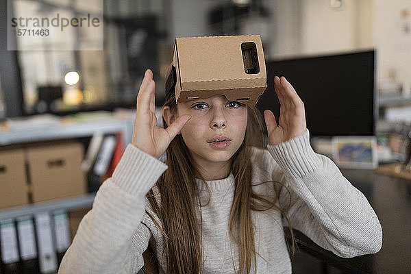 Mädchen mit VR-Kartonbrille im Büro