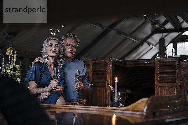 Porträt eines älteren Ehepaares bei einem Candlelight-Dinner auf einem Boot im Bootshaus
