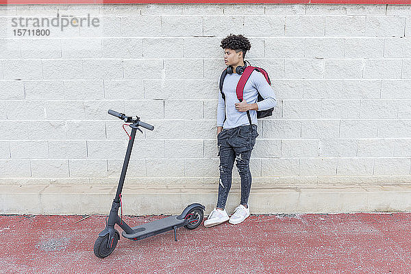 Junger Mann mit E-Scooter im Freien