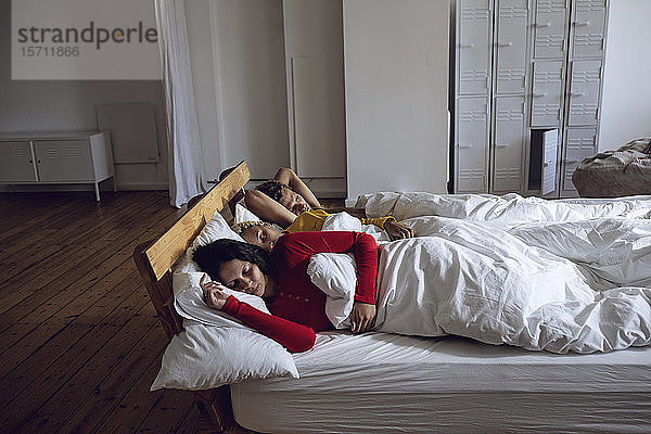 Drei Freunde schlafen zu Hause im Bett