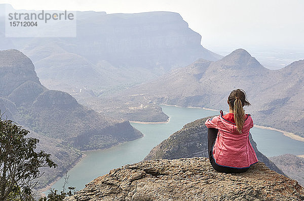 Frau sitzt auf einem Felsen und genießt die wunderschöne Landschaft unter sich  Blyde River Canyon  Südafrika.