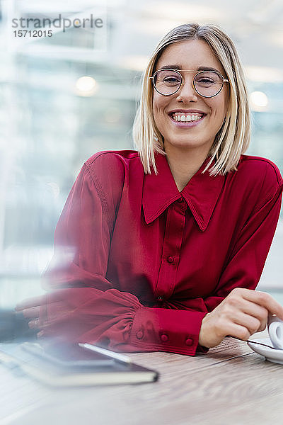 Porträt einer glücklichen jungen Geschäftsfrau in einem Cafe
