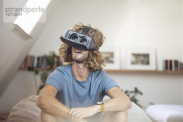 Junger Mann trägt VR-Brille zu Hause