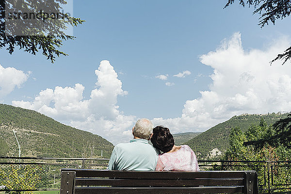 Rückenansicht eines älteren Ehepaares  das auf einer Bank sitzt und auf die Aussicht schaut  Jaca  Spanien