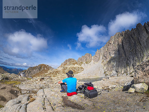 Älterer Mann macht eine Pause vom Wandern in der Berglandschaft  Fleimser Alpen  Trentino  Italien