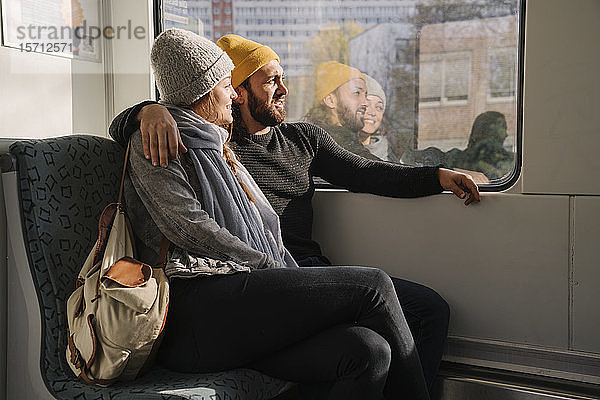 Junges Paar in einer U-Bahn  das aus dem Fenster schaut