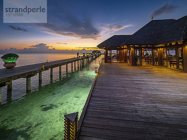 Malediven  Pier entlang der Küste Restaurant auf dem Süd Male Atoll in der Abenddämmerung