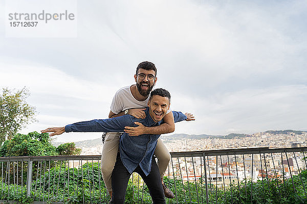 Porträt eines glücklichen schwulen Paares  das sich auf der Aussichtsterrasse amüsiert  Barcelona  Spanien