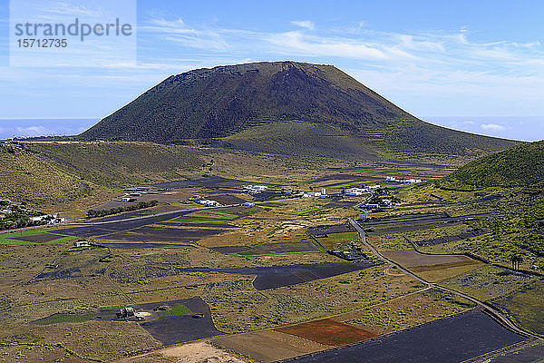 Spanien  Kanarische Inseln  Guinate  Felder vor einem ländlichen Dorf mit dem Vulkan Monte Corona im Hintergrund