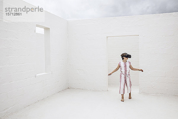 Kleines Mädchen entdeckt leeren Raum mit VR-Brille