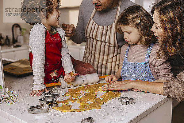Familie bereitet Weihnachtsplätzchen in der Küche zu