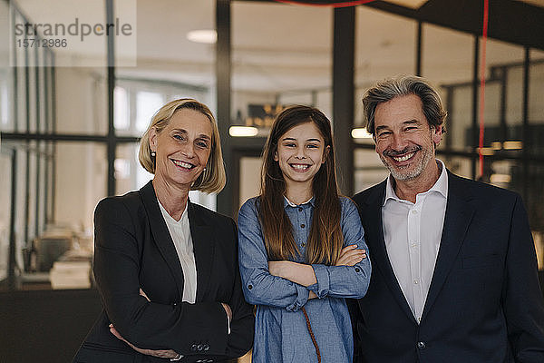 Porträt eines lächelnden Geschäftsmannes und einer Geschäftsfrau mit Mädchen im Amt