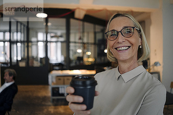 Porträt einer glücklichen reifen Geschäftsfrau bei einer Kaffeepause im Büro