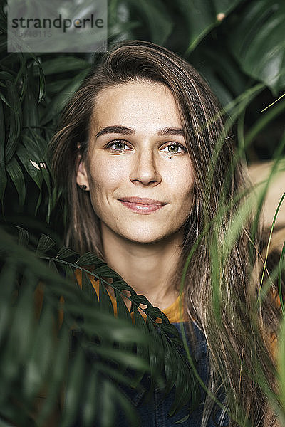 Porträt einer jungen Frau inmitten von Grünpflanzen