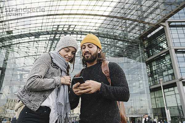 Junges Paar benutzt ein Smartphone am Hauptbahnhof  Berlin  Deutschland