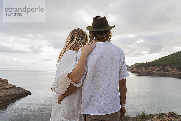 Rückansicht eines jungen Paares vor dem Meer mit Blick aufs Meer  Ibiza  Balearen  Spanien