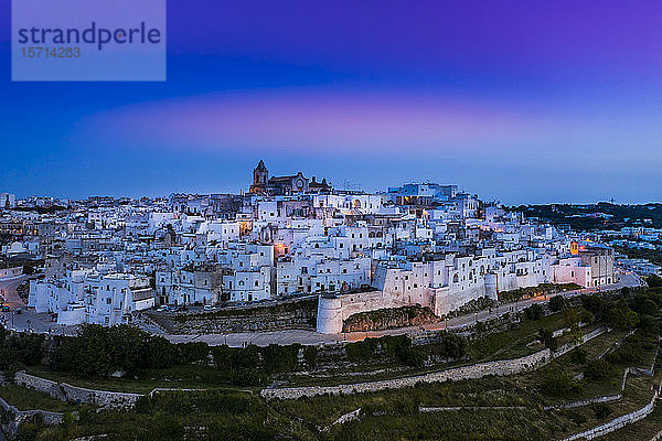 Italien  Provinz Brindisi  Ostuni  Luftaufnahme der Altstadtzitadelle umgeben von weißen Häusern in der Abenddämmerung